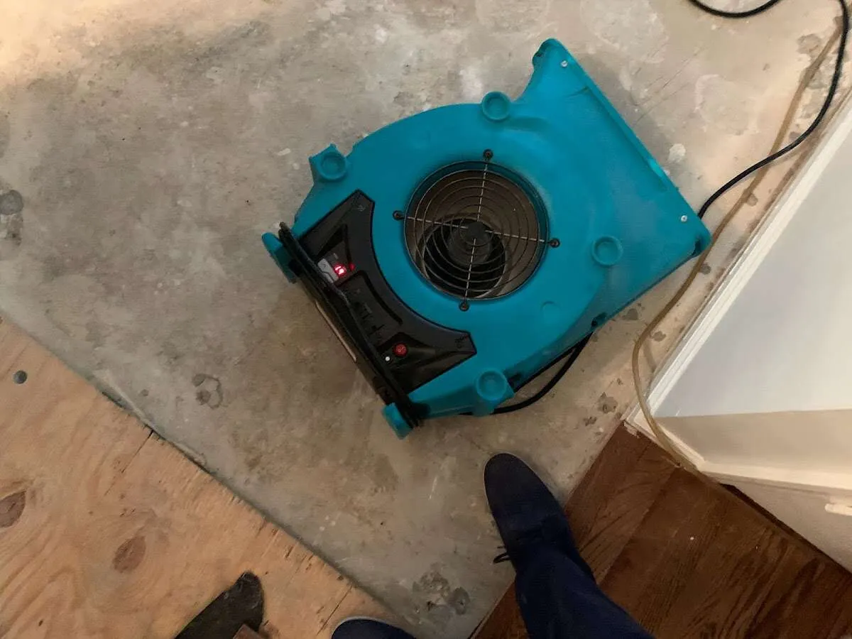 Air mover drying subfloor during Leak Detection & Repair in East Grand Forks